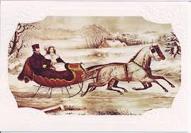 A man and woman ride in a horse-drawn sleigh through a snowy countryside, dressed in old-fashioned winter clothing. Trees and houses are visible in the background.