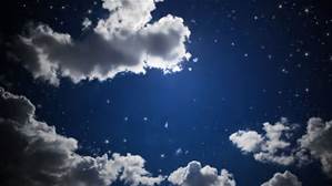 Night sky with fluffy clouds partially covering a bright moon, and numerous stars scattered across the deep blue background.